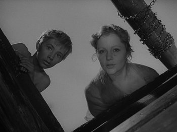 Movie still from “Ivan's Childhood” (1962), directed by Eduard Abalov – A man and a woman standing next to each other; Medium shot, Low angle