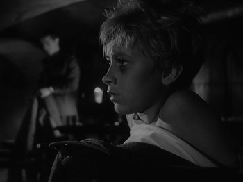 Movie still from “Ivan's Childhood” (1962), directed by Eduard Abalov – A young boy sitting in front of a mirror; Close Up shot, Low angle