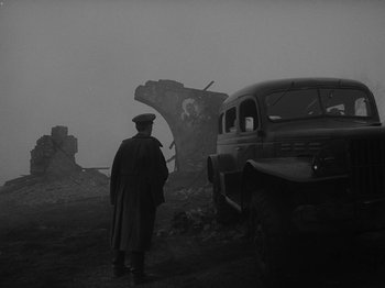Movie still from “Ivan's Childhood” (1962), directed by Eduard Abalov – An old car and an old truck in the middle of a field; Wide shot, Low angle