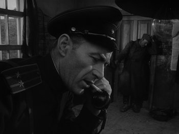Movie still from “Ivan's Childhood” (1962), directed by Eduard Abalov – A man in a military uniform smoking a pipe; Close Up shot, Low angle