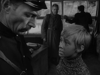 Movie still from “Ivan's Childhood” (1962), directed by Eduard Abalov – A young boy is talking to an older man; Medium shot, Over the shoulder angle