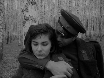 Movie still from “Ivan's Childhood” (1962), directed by Eduard Abalov – A man and a woman in military uniforms hugging each other; Medium shot, High angle