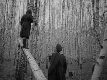 Movie still from “Ivan's Childhood” (1962), directed by Eduard Abalov – Two people standing on a log in the middle of a forest; Wide shot, Low angle