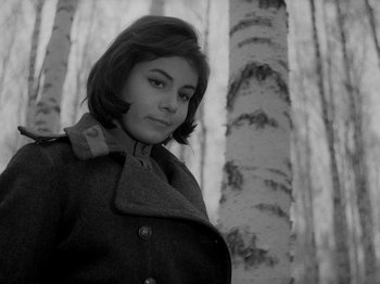 Movie still from “Ivan's Childhood” (1962), directed by Eduard Abalov – A black and white photo of a woman standing in front of trees; Close Up shot, Low angle