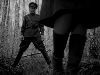 Movie still from “Ivan's Childhood” (1962), directed by Eduard Abalov – A man and a woman are standing in the woods; Wide shot, Low angle