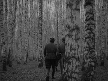 Movie still from “Ivan's Childhood” (1962), directed by Eduard Abalov – Two men are walking through the woods together; Wide shot, Low angle