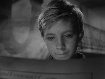 Movie still from “Ivan's Childhood” (1962), directed by Eduard Abalov – A young boy is looking at the camera; Close Up shot, High angle