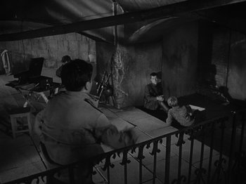 Movie still from “Ivan's Childhood” (1962), directed by Eduard Abalov – A black and white photo of people sitting on a balcony; Wide shot, High angle