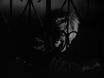 Movie still from “Ivan's Childhood” (1962), directed by Eduard Abalov – A person is looking at the camera through a fence; Extreme Close Up shot, Overhead angle