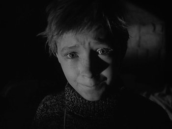 Movie still from “Ivan's Childhood” (1962), directed by Eduard Abalov – A young boy is looking into the camera; Close Up shot, High angle