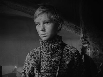Movie still from “Ivan's Childhood” (1962), directed by Eduard Abalov – A young woman wearing a sweater standing next to a tree; Close Up shot, Low angle