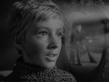 Movie still from “Ivan's Childhood” (1962), directed by Eduard Abalov – A young boy looking into the distance in a black and white photo; Close Up shot, Over the shoulder angle