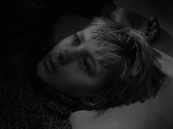 Movie still from “Ivan's Childhood” (1962), directed by Eduard Abalov – A young man laying on the ground looking at the camera; Close Up shot, High angle