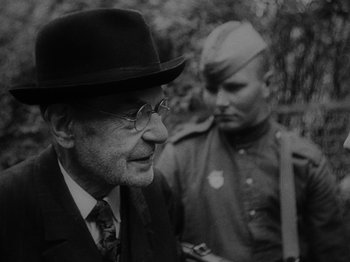 Movie still from “Ivan's Childhood” (1962), directed by Eduard Abalov – An older man wearing a hat and a tie; Close Up shot, Over the shoulder angle