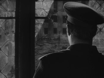Movie still from “Ivan's Childhood” (1962), directed by Eduard Abalov – A man wearing a hat looking out of a window; Close Up shot, Over the shoulder angle