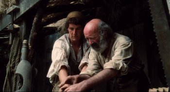 Movie still from “Jabberwocky” (1977), directed by Terry Gilliam – A man with a beard and a man with a hat; Medium shot, Low angle