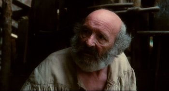 Movie still from “Jabberwocky” (1977), directed by Terry Gilliam – An old man with a beard and a mustache; Close Up shot, Over the shoulder angle