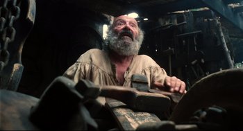 Movie still from “Jabberwocky” (1977), directed by Terry Gilliam – An old man with a beard is sitting in a chair; Close Up shot, Low angle