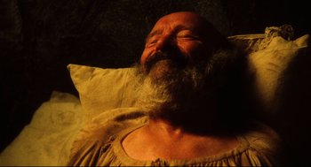 Movie still from “Jabberwocky” (1977), directed by Terry Gilliam – An old man with a beard is laying in a bed; Close Up shot, Overhead angle