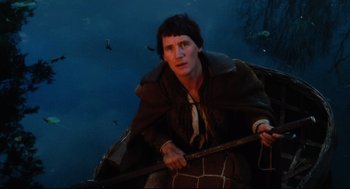 Movie still from “Jabberwocky” (1977), directed by Terry Gilliam – A man in a boat with a stick in his hand; Medium shot, High angle