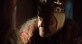 Movie still from “Jabberwocky” (1977), directed by Terry Gilliam – An old man wearing a crown and a beard; Close Up shot, Low angle