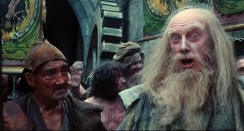 Movie still from “Jabberwocky” (1977), directed by Terry Gilliam – A group of men standing next to each other; Medium shot, Low angle