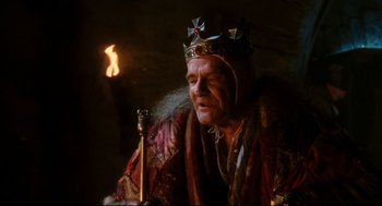 Movie still from “Jabberwocky” (1977), directed by Terry Gilliam – A man with a crown and a scepter in his hand; Close Up shot, Low angle