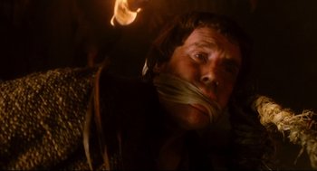 Movie still from “Jabberwocky” (1977), directed by Terry Gilliam – A man with his mouth taped shut and a fire in the background; Close Up shot, High angle