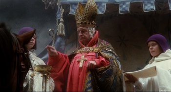 Movie still from “Jabberwocky” (1977), directed by Terry Gilliam – An old man wearing a red robe and a crown; Medium shot, Low angle