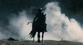 Movie still from “Jabberwocky” (1977), directed by Terry Gilliam – A person on a horse with horns on its head; Wide shot, Low angle