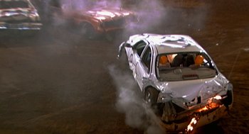 Movie still from “Jackass: The Movie” (2002), directed by Jeff Tremaine – A car that has been wrecked in a fire; Wide shot, High angle