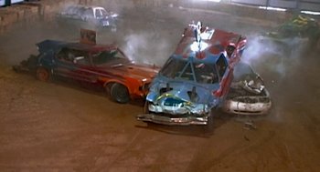 Movie still from “Jackass: The Movie” (2002), directed by Jeff Tremaine – Two cars that have been wrecked in a car race; Wide shot, High angle