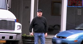 Movie still from “Jackass: The Movie” (2002), directed by Jeff Tremaine – A man standing in front of a house; Medium shot, Over the shoulder angle