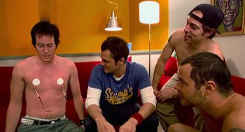 Movie still from “Jackass: The Movie” (2002), directed by Jeff Tremaine – A group of men sitting on a couch; Medium shot, High angle