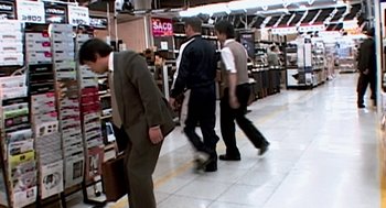 Movie still from “Jackass: The Movie” (2002), directed by Jeff Tremaine – A group of people walking around a store; Wide shot, High angle