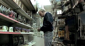 Movie still from “Jackass: The Movie” (2002), directed by Jeff Tremaine – An older man is looking at a shelf in a store; Medium shot, High angle