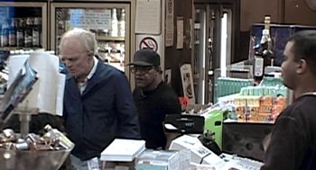 Movie still from “Jackass: The Movie” (2002), directed by Jeff Tremaine – Two men standing in front of boxes of food in a store; Wide shot, High angle