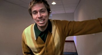 Movie still from “Jackass: The Movie” (2002), directed by Jeff Tremaine – A young man in a striped sweater smiling for the camera; Medium shot, High angle