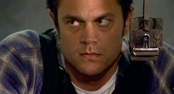 Movie still from “Jackass: The Movie” (2002), directed by Jeff Tremaine – A person holding a knife; Close Up shot, Overhead angle