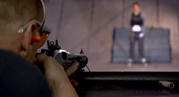Movie still from “Jackass: The Movie” (2002), directed by Jeff Tremaine – A person holding a gun in their hand; Close Up shot, Low angle
