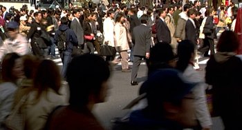 Movie still from “Jackass: The Movie” (2002), directed by Jeff Tremaine – A crowd of people walking down a street; Wide shot, High angle