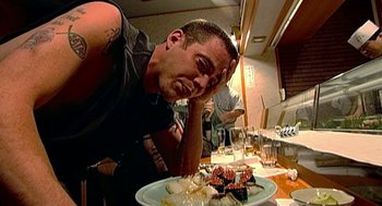 Movie still from “Jackass: The Movie” (2002), directed by Jeff Tremaine – A man sitting in front of a plate of food; Close Up shot, High angle
