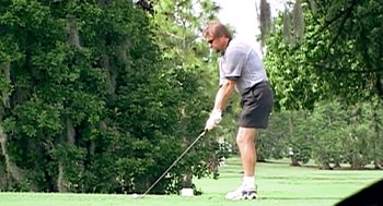 Movie still from “Jackass: The Movie” (2002), directed by Jeff Tremaine – A man is swinging a golf club on a golf course; Medium shot, Low angle