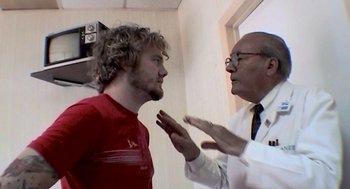 Movie still from “Jackass: The Movie” (2002), directed by Jeff Tremaine – A man and a doctor talking to each other; Close Up shot, Low angle
