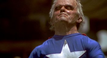 Movie still from “Jackass: The Movie” (2002), directed by Jeff Tremaine – An older man wearing a blue shirt with a white star on it; Close Up shot, Low angle