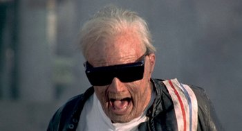Movie still from “Jackass: The Movie” (2002), directed by Jeff Tremaine – An older man wearing sunglasses and a white shirt; Close Up shot, Low angle