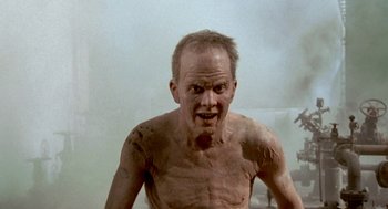 Movie still from “Jackass: The Movie” (2002), directed by Jeff Tremaine – A shirtless man with no shirt in a bathroom; Medium shot, Low angle