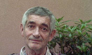 Movie still from “Jacquot of Nantes” (1991), directed by Agnès Varda – An older man with grey hair is smiling for the camera; Close Up shot, High angle