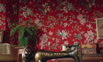 Movie still from “Jacquot of Nantes” (1991), directed by Agnès Varda – A sewing machine sitting on top of a red wall; Medium shot, High angle