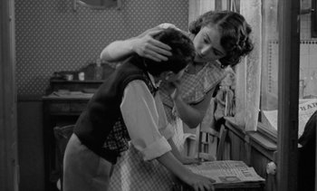 Movie still from “Jacquot of Nantes” (1991), directed by Agnès Varda – An old photo of a woman and a young boy; Medium shot, Low angle